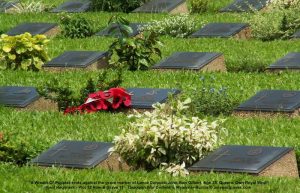 A Wreath-Of-Poppies rests against the grave marker of Lance Corporal John Alan Gilbert, Age 25, Queens Own Royal West Kent Regiment - Plot 12 Row B Grave 11, Taukkyan War Cemetery, Myanmar-Burma